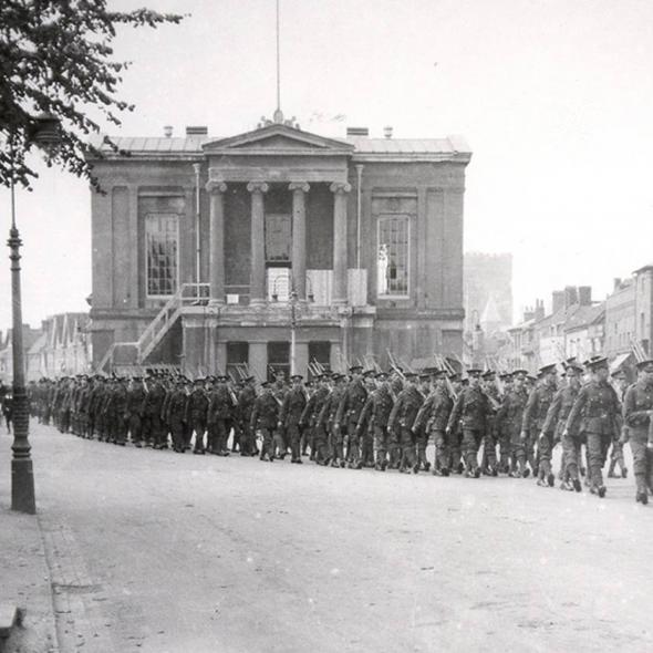 Soldiers marching in front of the old Town Hall during the First World War