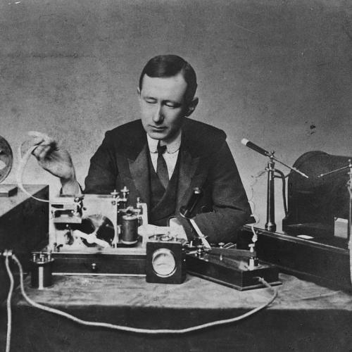 Electrical engineer Guglielmo Marconi with some of his radio equipment including the spark-gap transmitter (right) and coherer receiver (left) he used in some of his first long distance transmissions during the 1890s.