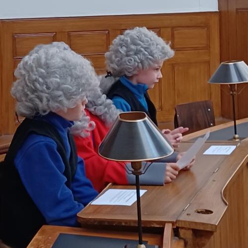 Children dressed as magistrates in the courtroom 