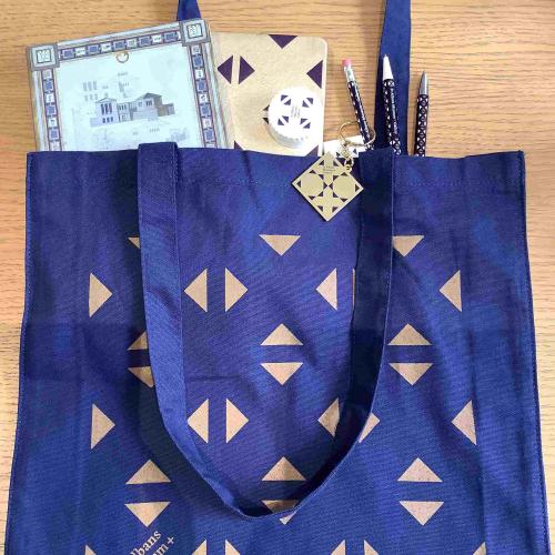 a tote bag full of stationery with the museum brand