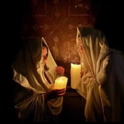 candlelit figures in front of wall paintings