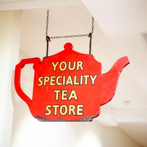 A tea room sign in the shape of a teapot on display in the gallery.