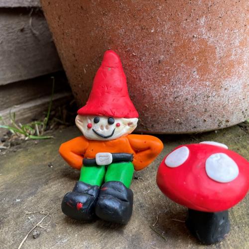 colourful clay gnome and toadstool with plant pot