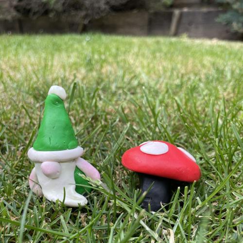 colourful clay gnome and toadstool on grass