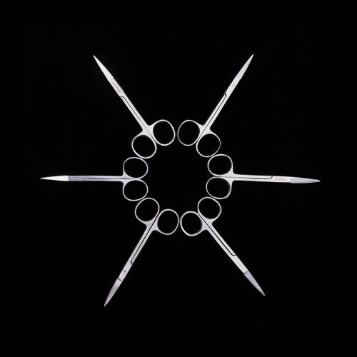 Surgical tools arranged to make a star shape on a black background