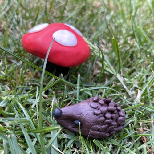 colourful clay hedgehog and toadstool on grass