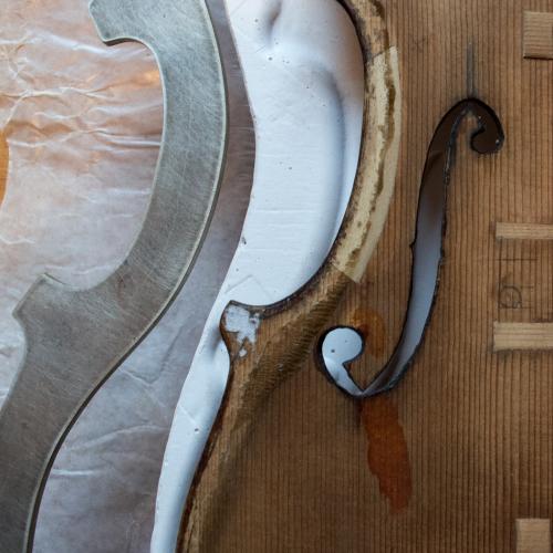 A part made violin showing the layers that will make the body