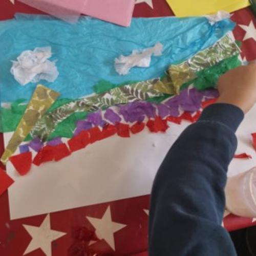 child's hand creating landscape collage
