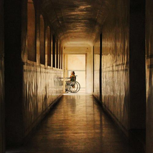 Temporary II, photograph of a corridor with person in a wheelchair in the background
