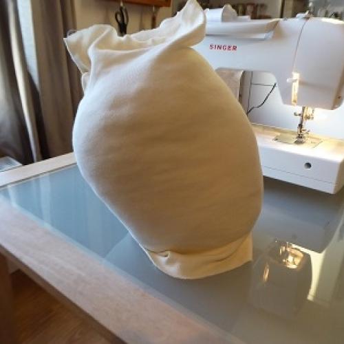Photo of the mannequin head being covered by soft cotton fabric