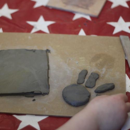 clay board with child's hand and clay