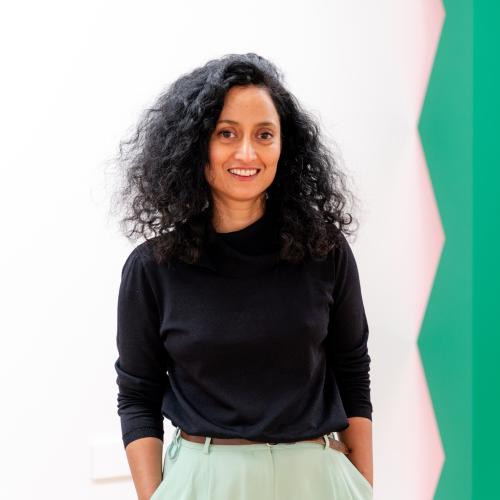 Artist Rana Begum standing to the left of one of her sculptures.