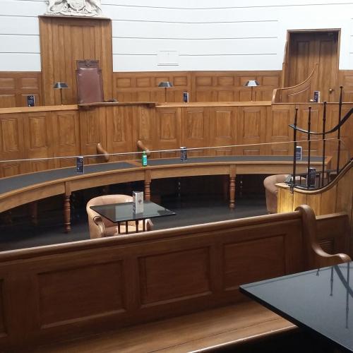 The Courtroom with tables and chairs arranged with more space between them and fewer tables