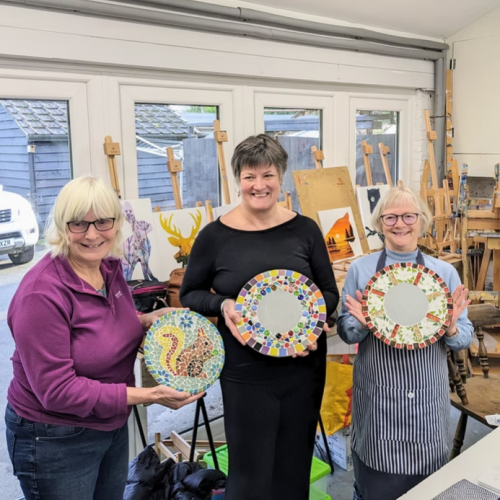 women holding up their mosaics