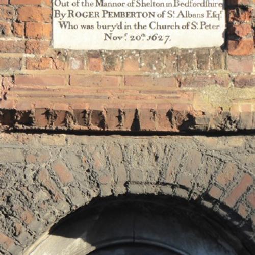 This image shows the doorway carving and the information plaque about Roger Pemberton