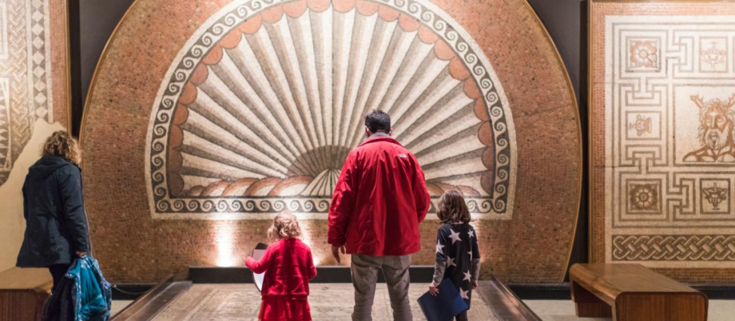 Photo of visitors admiring the shell mosaic at Verulamium Museum