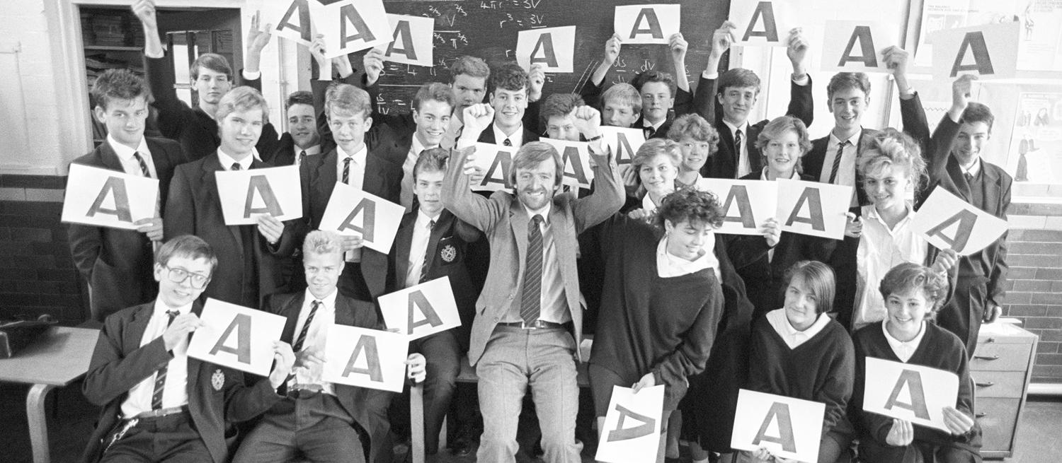 Black and white image of Beaumont students holding up A grades 1987