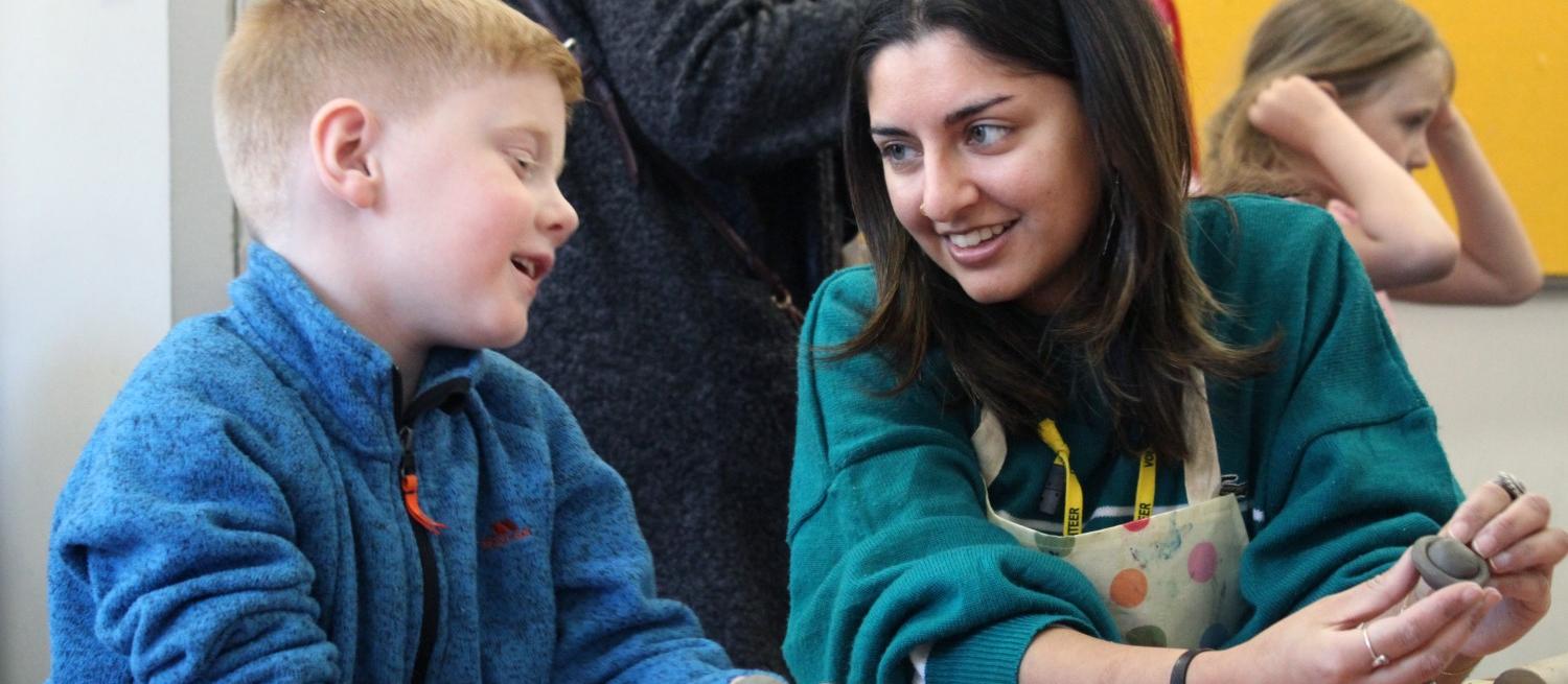 volunteer and child enjoying craft activity