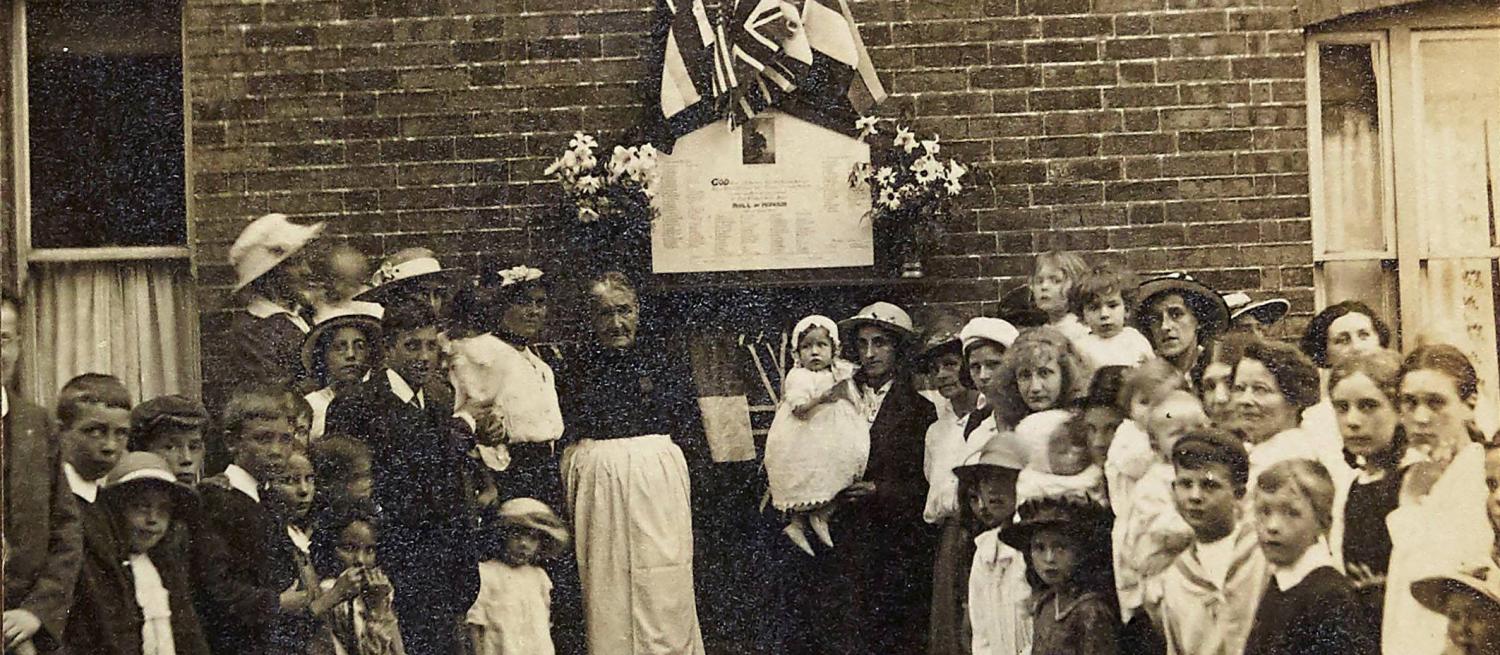 A street war memorial in St Albans surrounded by local residents