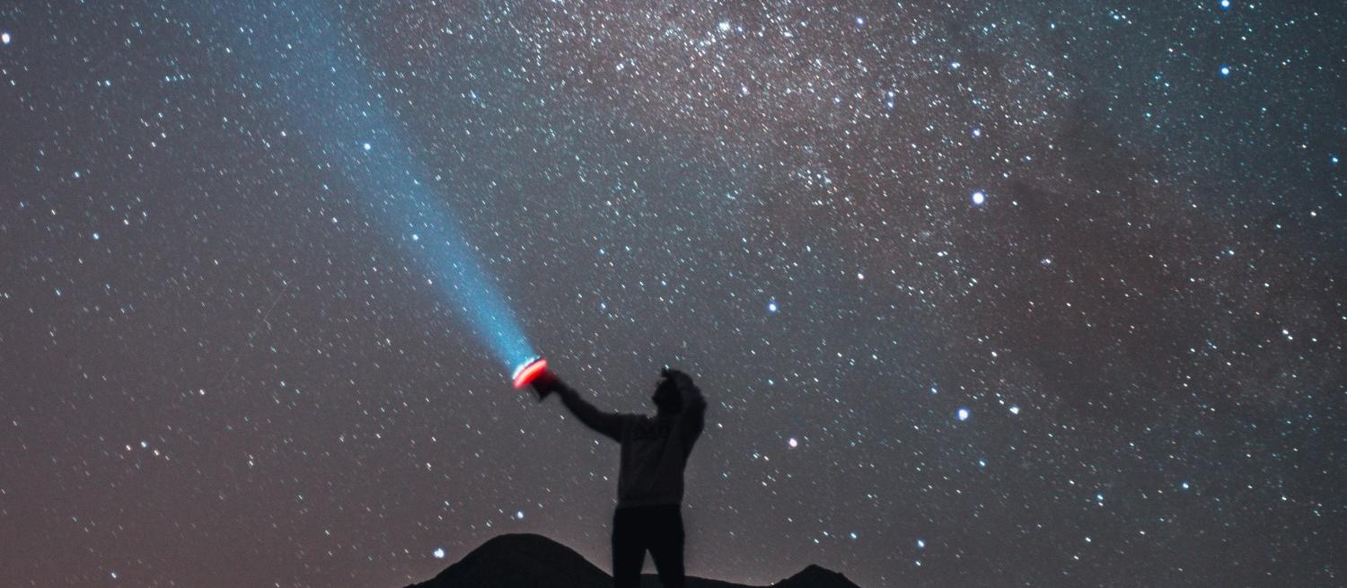 tomas-anunziata silhouette shining torch at night sky