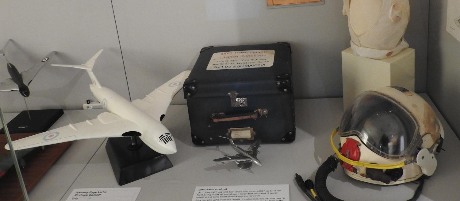 An exhibition case containing a flight helmet and model HP Victor aircraft