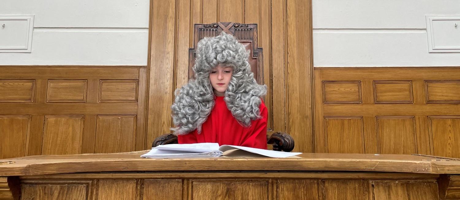 child dressed as magistrate sitting in courtroom