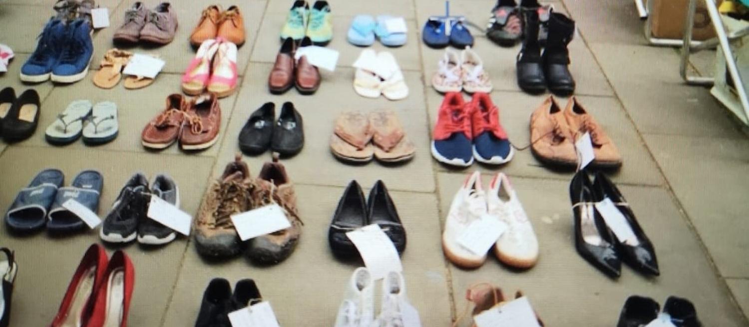 empty shoes in rows on pavement to symbolise the millions missing through chronic illness