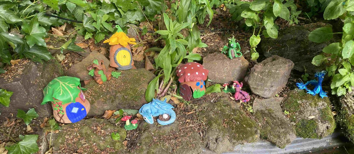 Fairy garden with flowerpot houses and polymer clay dragons
