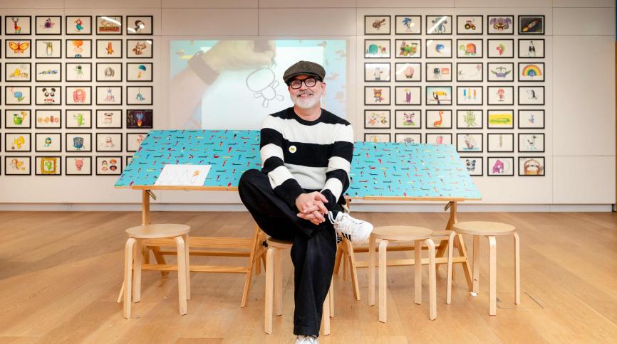 Rob Biddulph sitting in the exhibition