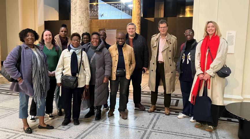 A group of around 15 people standing in a classical interior.