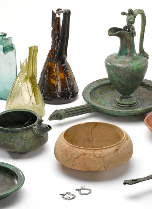 A selection of roman artefacts including samian ware dishes and glass and metal jugs
