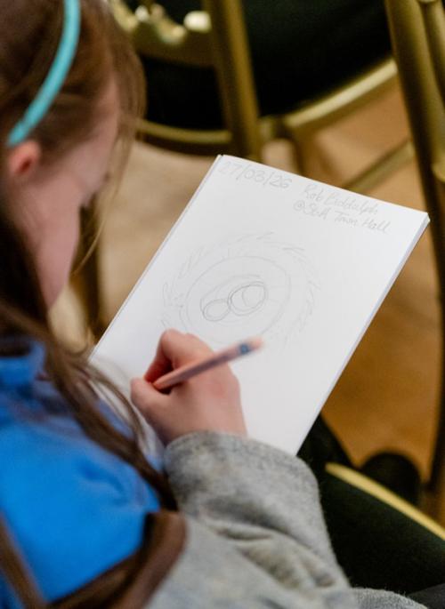 child holding pencil and drawing