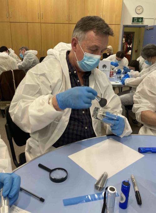 man in forensic suit dusting for finger prints