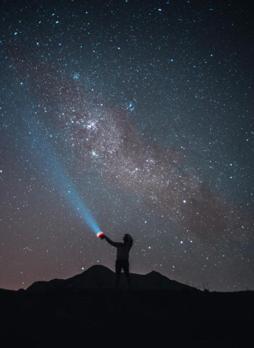 Tomas Anunziata image of silhouette shining torch at night sky